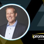 Smiling man in a suit inside a circular frame with a geometric background and the ipromoteu logo in the corner (branding scene).