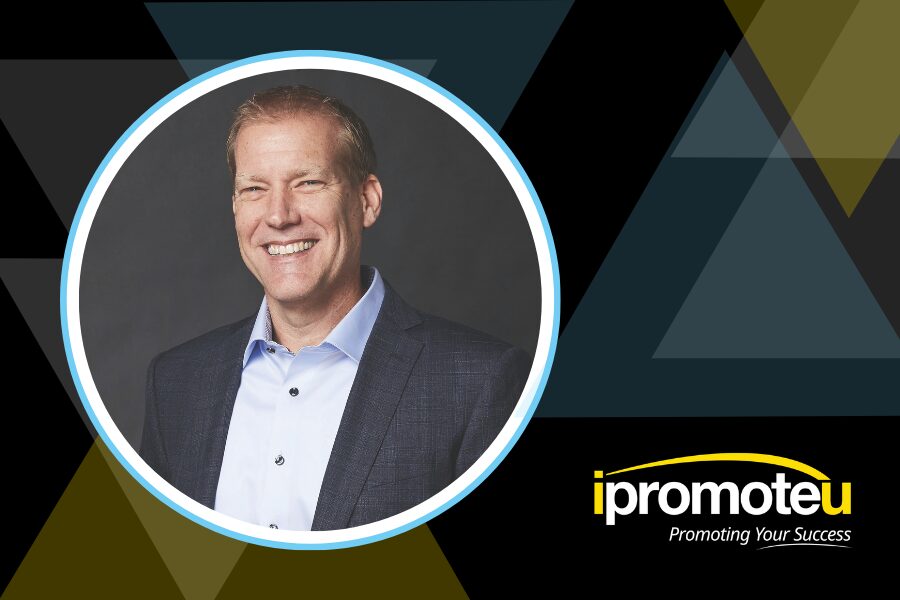 Smiling man in a suit inside a circular frame with a geometric background and the ipromoteu logo in the corner (branding scene).